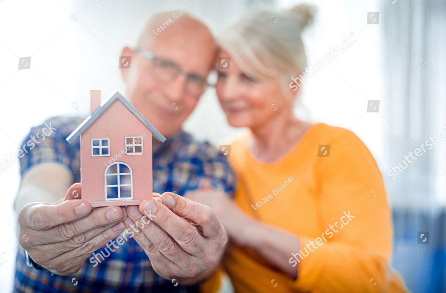 stock-photo-new-house-concept-happy-senior-couple-holding-small-home-model-1457557406